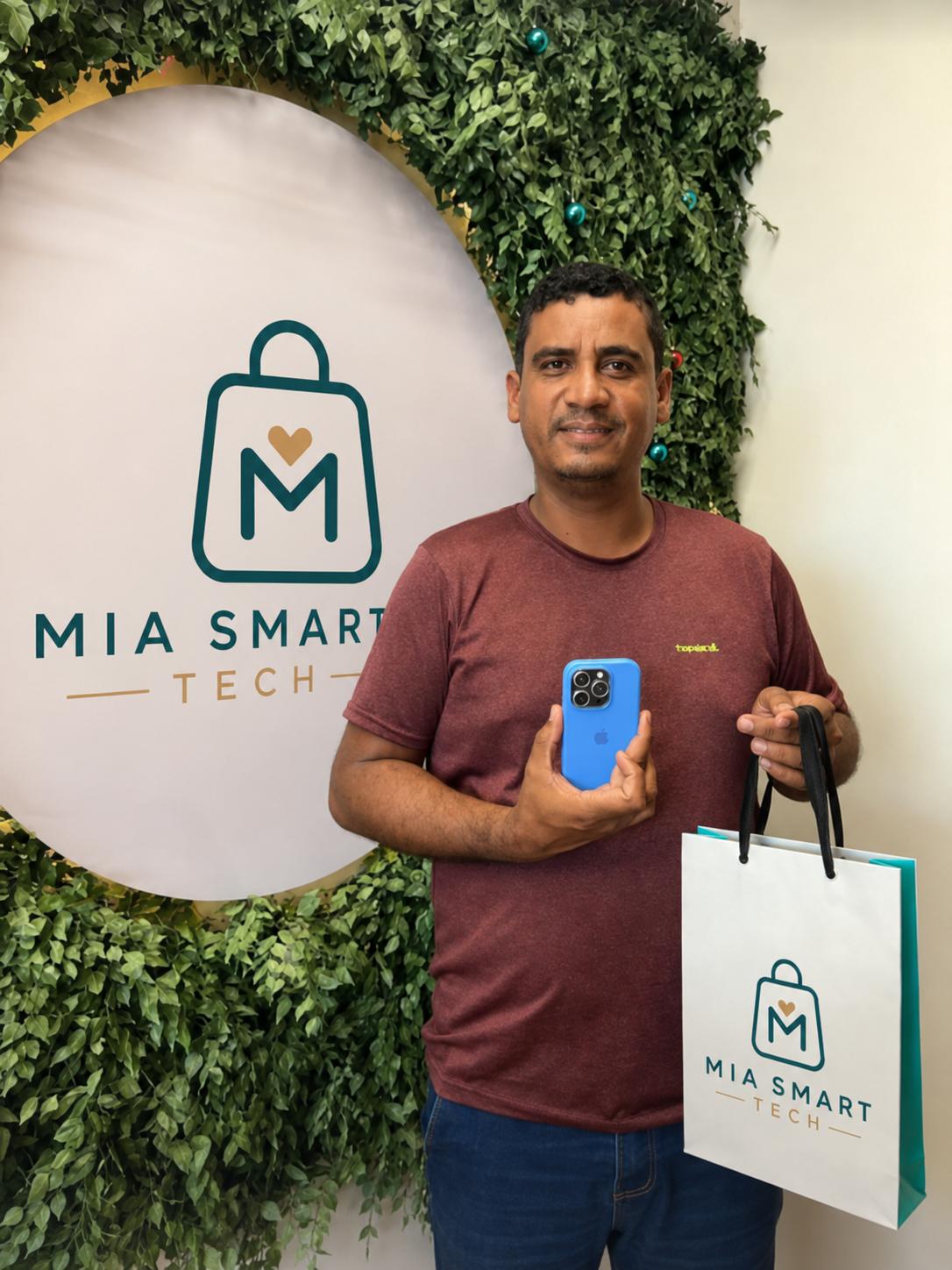 Cliente mostrando su nuevo iPhone y bolsa de MIA SMART TECH dentro de la tienda